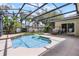 Backyard pool area featuring a screened-in patio, landscaping and seating for outdoor relaxation at 7288 Winding Lake Cir, Oviedo, FL 32765
