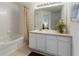 Well lit bathroom features a shower/tub combo and a white vanity with ample storage at 7663 Fitzclarence St, Kissimmee, FL 34747