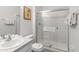Bathroom with glass enclosed shower, tile flooring, and a modern sink at 7663 Fitzclarence St, Kissimmee, FL 34747