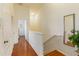 Upstairs hallway with wood flooring and white trim at 7663 Fitzclarence St, Kissimmee, FL 34747