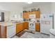 Bright kitchen features wood cabinets, white appliances and updated flooring at 7663 Fitzclarence St, Kissimmee, FL 34747