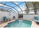 Private screened-in pool with clear blue water and patio seating at 7663 Fitzclarence St, Kissimmee, FL 34747
