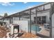 Screened-in pool area with patio furniture and a view of the back of the house at 7663 Fitzclarence St, Kissimmee, FL 34747