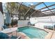 A screened-in private pool area with blue lounge chairs and a round table with an umbrella at 7663 Fitzclarence St, Kissimmee, FL 34747