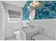 Charming bathroom showcases unique floral wallpaper, a decorative mirror, and a sleek white vanity with ample lighting at 808 Malone Dr, Orlando, FL 32810