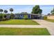 Well-kept home with a lush green lawn, mature landscaping, and a covered carport for convenient parking at 808 Malone Dr, Orlando, FL 32810