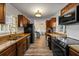 Galley kitchen boasts granite countertops, wood cabinetry, and stainless steel appliances, offering style and functionality at 808 Malone Dr, Orlando, FL 32810