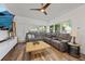 Sunlit living room features a large sectional sofa, wood floors, and expansive windows offering serene outdoor views at 808 Malone Dr, Orlando, FL 32810