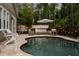 Tranquil backyard features a dark-bottom pool, lounge seating, string lights, and privacy fencing at 9534 Piccadilly Sky Way, Orlando, FL 32827