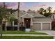 Charming home with a well-manicured lawn, stone accents, and a two-car garage at 9534 Piccadilly Sky Way, Orlando, FL 32827
