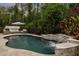 Outdoor pool area with a waterfall feature, lush greenery, and comfortable seating for relaxation at 9534 Piccadilly Sky Way, Orlando, FL 32827
