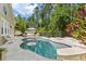 Beautiful backyard pool with stone accents and an outdoor seating area surrounded by lush trees at 9534 Piccadilly Sky Way, Orlando, FL 32827