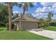 Charming one-story home with an attached garage, lush landscaping, and a driveway at 1022 Pinehurst Ct, Oviedo, FL 32765