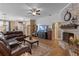 Cozy living room with a brick fireplace, wood floors, and a comfortable leather sectional sofa at 1022 Pinehurst Ct, Oviedo, FL 32765