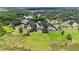 Aerial view showcasing large property with lush green lawn, swimming pool, and nearby pond and tennis courts at 1093 Hidden Harbor Ln, Kissimmee, FL 34746