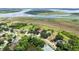 Aerial view of a beautiful lakeside home with a pool, tennis court, and mature landscaping at 1093 Hidden Harbor Ln, Kissimmee, FL 34746