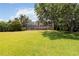 Expansive backyard with lush green grass, mature trees, and a screened-in pool enclosure at 1093 Hidden Harbor Ln, Kissimmee, FL 34746