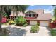 Attractive brick home with mature landscaping, two-car garage, and ample parking on circular driveway at 1093 Hidden Harbor Ln, Kissimmee, FL 34746