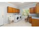 Laundry room featuring modern washer and dryer with sink, ample storage, and window at 1093 Hidden Harbor Ln, Kissimmee, FL 34746