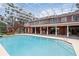 Spacious screened-in pool area with outdoor seating, two-story home with a balcony, and a staircase at 1093 Hidden Harbor Ln, Kissimmee, FL 34746