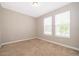 This bedroom features neutral walls, plush carpeting, and natural light from its two sunny windows at 11054 Cyrilla Woods Dr, Orlando, FL 32832