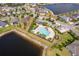 A high-angle shot of a community pool surrounded by lush landscaping and ample parking at 11054 Cyrilla Woods Dr, Orlando, FL 32832