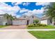 Inviting one-story home boasts a brick driveway, manicured front yard, and a convenient two-car garage at 11054 Cyrilla Woods Dr, Orlando, FL 32832