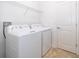 Clean laundry room equipped with a washer, dryer, shelving, and tile floor at 11054 Cyrilla Woods Dr, Orlando, FL 32832