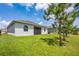 Backyard with green grass, lush trees, and rear exterior of home at 1167 Celery Oaks Ln, Sanford, FL 32771
