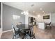 Open-concept dining area adjacent to a modern kitchen, featuring unique chairs and stylish lighting at 1167 Celery Oaks Ln, Sanford, FL 32771