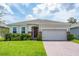 Charming single-story home featuring a well-manicured lawn, brick-accented entryway, and a two-car garage at 1167 Celery Oaks Ln, Sanford, FL 32771