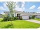Charming single-story home with well-maintained lawn, brick driveway, and two car garage at 1167 Celery Oaks Ln, Sanford, FL 32771