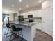 Well-lit kitchen with white cabinets, stainless steel appliances, and an island with bar seating, open to the dining area at 1167 Celery Oaks Ln, Sanford, FL 32771