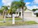 Charming single-Gathering home with a well-maintained lawn and mature palm trees in the front yard at 12112 Shallot St, Orlando, FL 32837