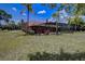 A large grassy backyard features a home with screened in pool and patio at 12202 Rambling Oak Blvd, Orlando, FL 32832