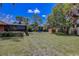 Large backyard with mature landscaping, featuring a shed and trampoline, offers ample space for recreation at 12202 Rambling Oak Blvd, Orlando, FL 32832