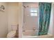 Bathroom featuring a white bathtub, shower with curtain, and a window for natural light at 12202 Rambling Oak Blvd, Orlando, FL 32832
