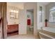 Open bathroom with a corner tub, vanity, and private toilet room at 12202 Rambling Oak Blvd, Orlando, FL 32832