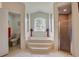 Bright bathroom with a soaking tub, glass block window, and separate shower at 12202 Rambling Oak Blvd, Orlando, FL 32832