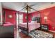 Elegant bedroom showcasing a four-poster bed, bold red walls, and stylish decor at 12202 Rambling Oak Blvd, Orlando, FL 32832
