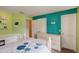 Bedroom with a bed, built-in shelving, large window, and colorful, light green and turquoise walls at 12202 Rambling Oak Blvd, Orlando, FL 32832