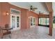Covered outdoor patio area with tile flooring, ceiling fans, and french doors at 12202 Rambling Oak Blvd, Orlando, FL 32832