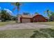 Charming exterior of the home with a spacious driveway, lush landscaping, and a well-maintained facade at 12202 Rambling Oak Blvd, Orlando, FL 32832