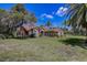 Beautiful single-story home with brick facade, manicured lawn, and mature shade trees at 12202 Rambling Oak Blvd, Orlando, FL 32832