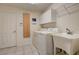Bright laundry room with white washer, dryer, sink and cabinet at 12202 Rambling Oak Blvd, Orlando, FL 32832