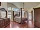 Stately main bedroom has a four-poster bed frame, vaulted ceilings, and an abundance of natural light at 12202 Rambling Oak Blvd, Orlando, FL 32832