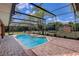Screened-in pool with a hot tub surrounded by brick patio and green backyard at 12202 Rambling Oak Blvd, Orlando, FL 32832