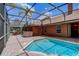 Screened in pool area with outdoor kitchen and view of backyard at 12202 Rambling Oak Blvd, Orlando, FL 32832