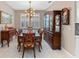 Elegant dining room with a large wooden table, matching chairs, stylish chandelier, and shuttered windows at 12289 Prairie Plantation Way, Orlando, FL 32824