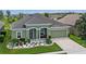 Inviting single-story home with a well-manicured lawn and colorful flower beds enhancing its curb appeal at 12289 Prairie Plantation Way, Orlando, FL 32824